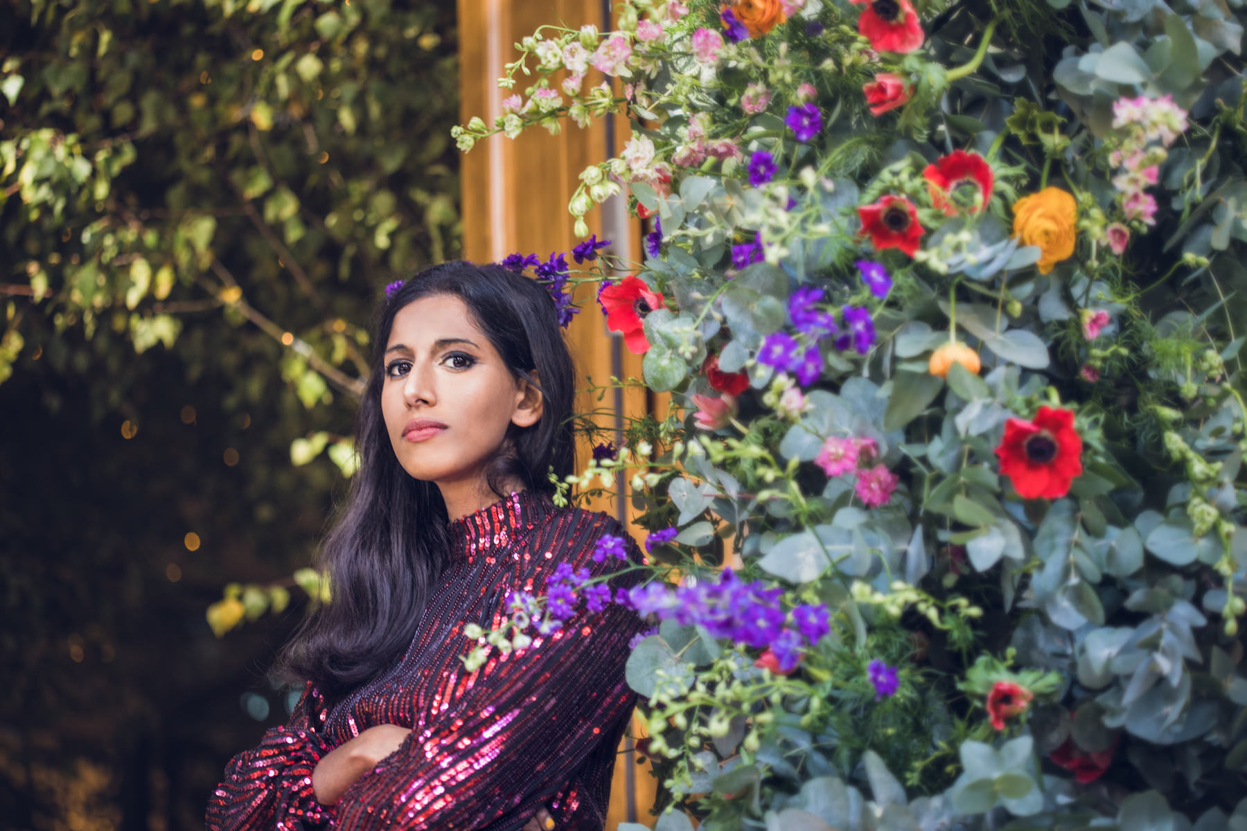 A florist beside a wall of seasonal flowers